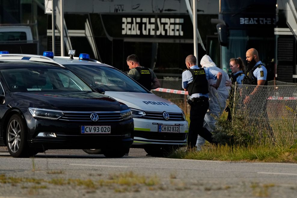 Einsatzkräfte der Polizei führen eine Person zu einem Polizeifahrzeug neben dem Einkaufszentrum Field's.