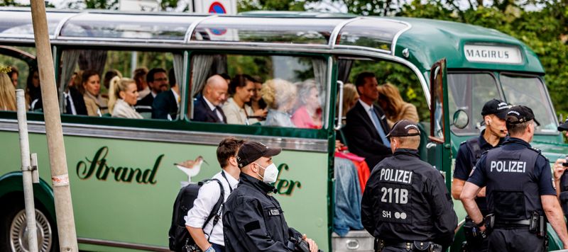 Hochzeitsgäste sitzen in einem grünen historischen Bus