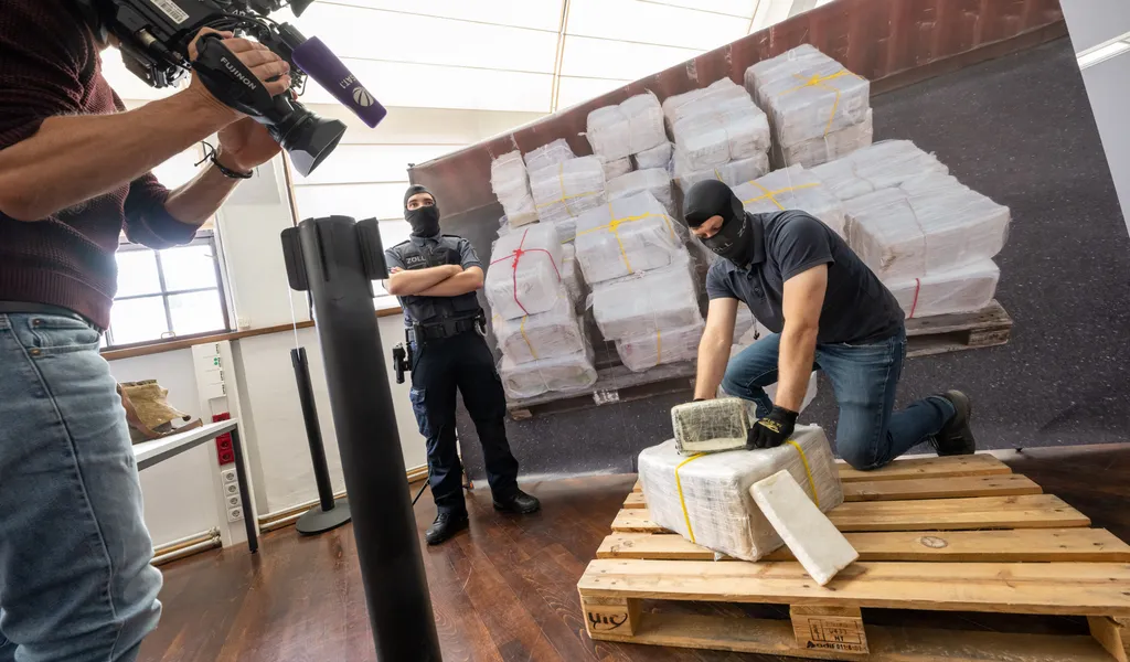 Ein Zollbeamter kniet vor einem Teil des sichergestellten Kokains.