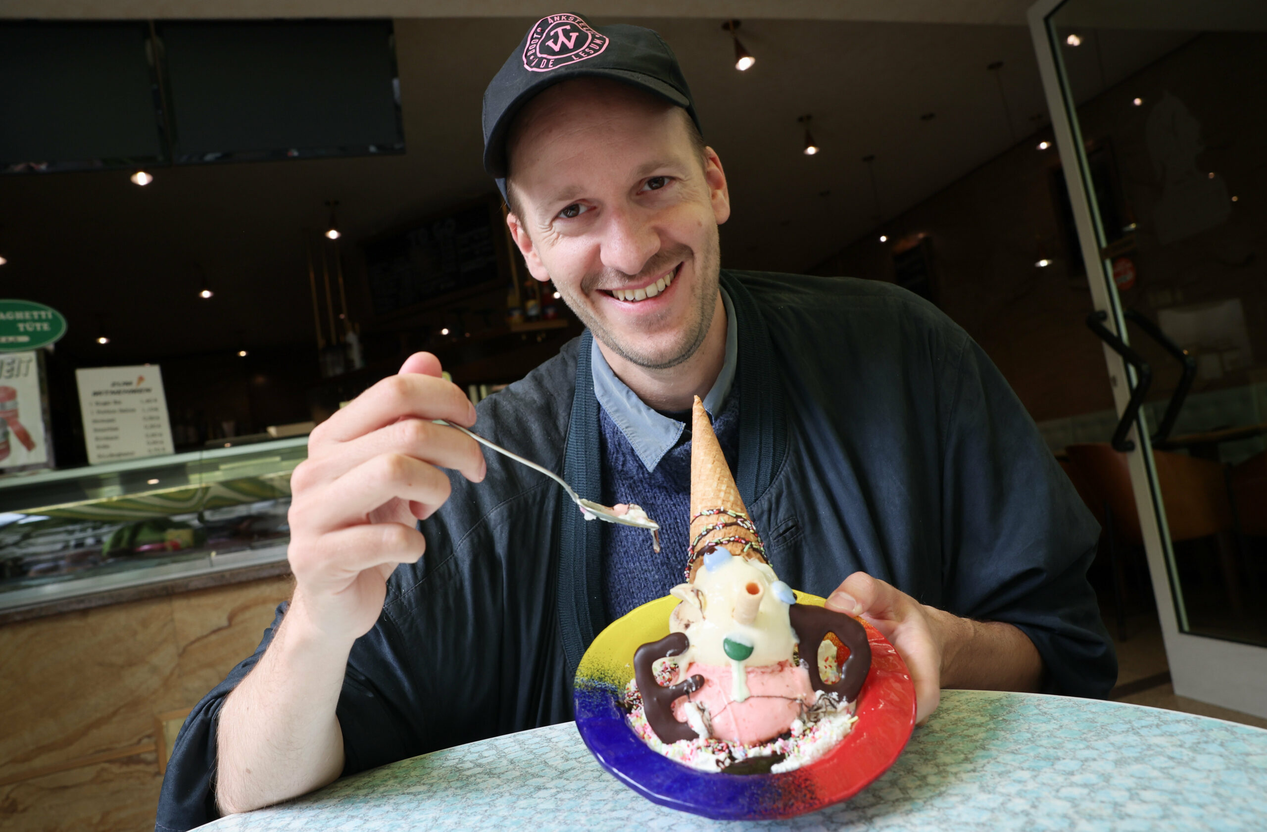Der Autor Leonhard Hieronymi isst ein Pinocchio-Eis bei einem Interview im Eiscafe Dante in Hamburg.