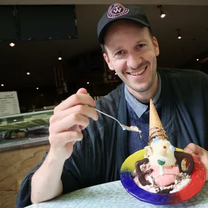 Der Autor Leonhard Hieronymi isst ein Pinocchio-Eis bei einem Interview im Eiscafe Dante in Hamburg.