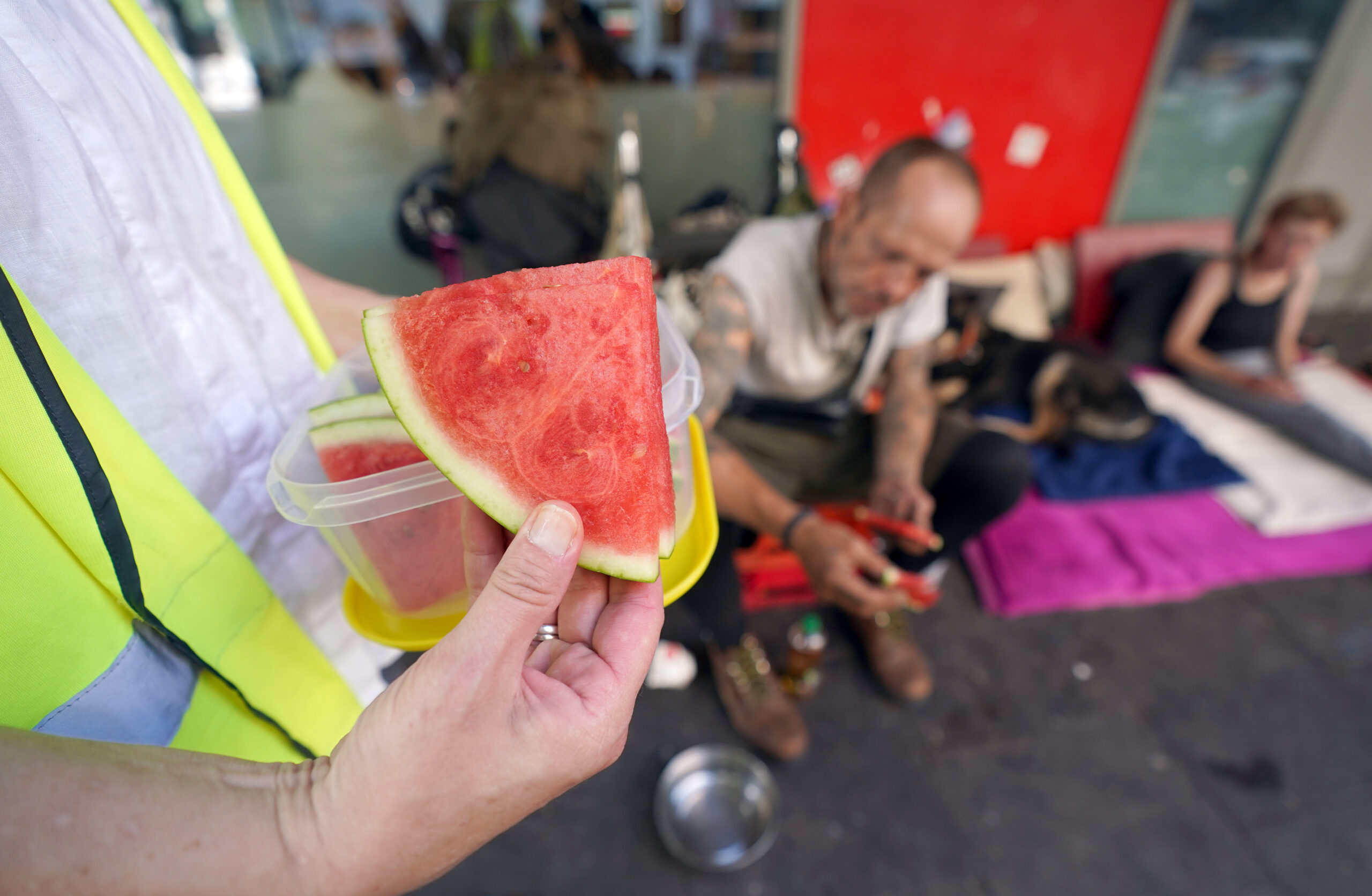 Wassermelonen-Stücke werden an Obdachlose verteilt.