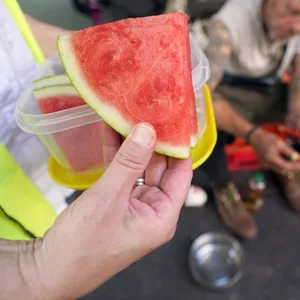 Wassermelonen-Stücke werden an Obdachlose verteilt.