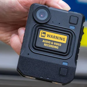 Eine neue Bodycam wird bei der Vorstellung des Systems vor einem Polizeiauto gehalten.