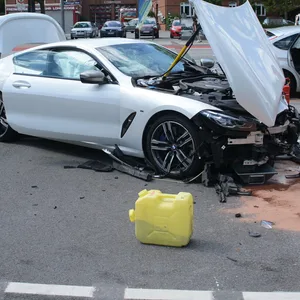 Die beschädigten Fahrzeuge stehen neben einem Feuerwehr- und einem Polizeiauto.