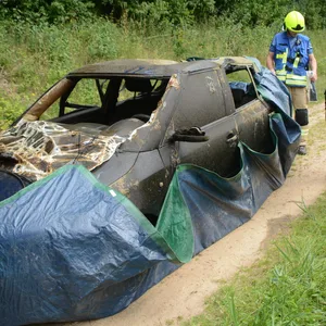 Ein kaputtes Auto ist in eine Plane gewickelt.