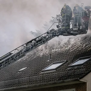 Die Feuerwehr bei den Löscharbeiten am Mehrfamilienhaus.