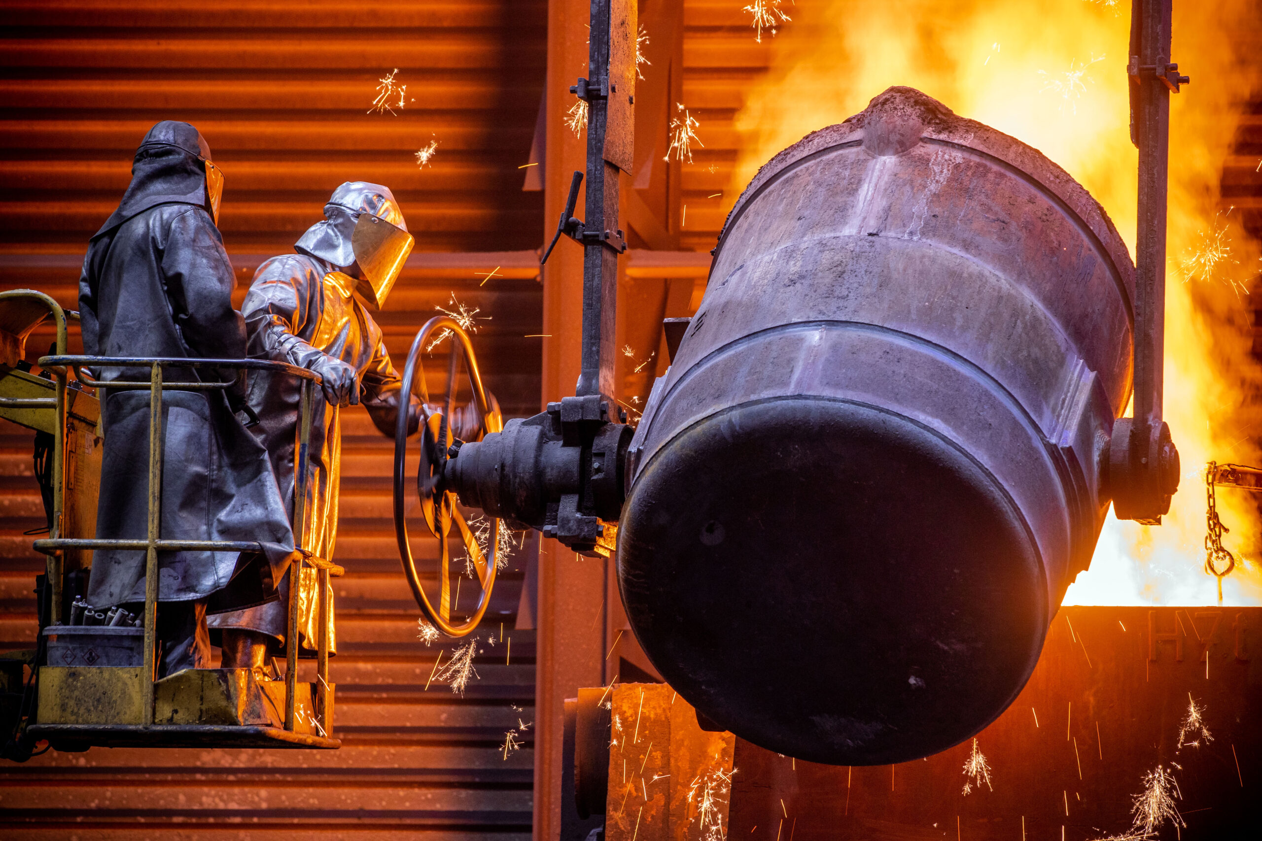 Arbeiter gießen flüssiges Eisen mit einer Temperatur von 1.400 Grad in der Eisengießerei Torgelow in vorbereitete Formen.