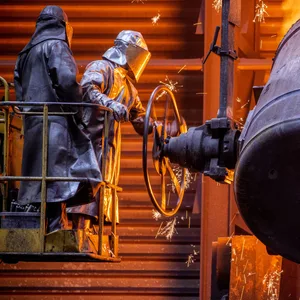 Arbeiter gießen flüssiges Eisen mit einer Temperatur von 1.400 Grad in der Eisengießerei Torgelow in vorbereitete Formen.