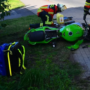 Rettungskräfte stehen neben dem grünen Motorrad, das am Seitenrand liegt