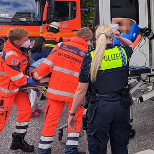 Rettungskräfte bringen einen Mann auf einer Trage in den Krankenwagen