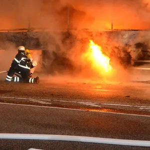 Feuerwehrleute löschen einen brennenden Reisebus in Hamburg-Horn.