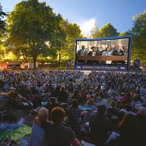 Der Schanzenpark dunkel, Menschen sitzen auf Stühlen und Decken und schauen auf eine Leinwand, auf der „Monsieur Claude“ läuft.