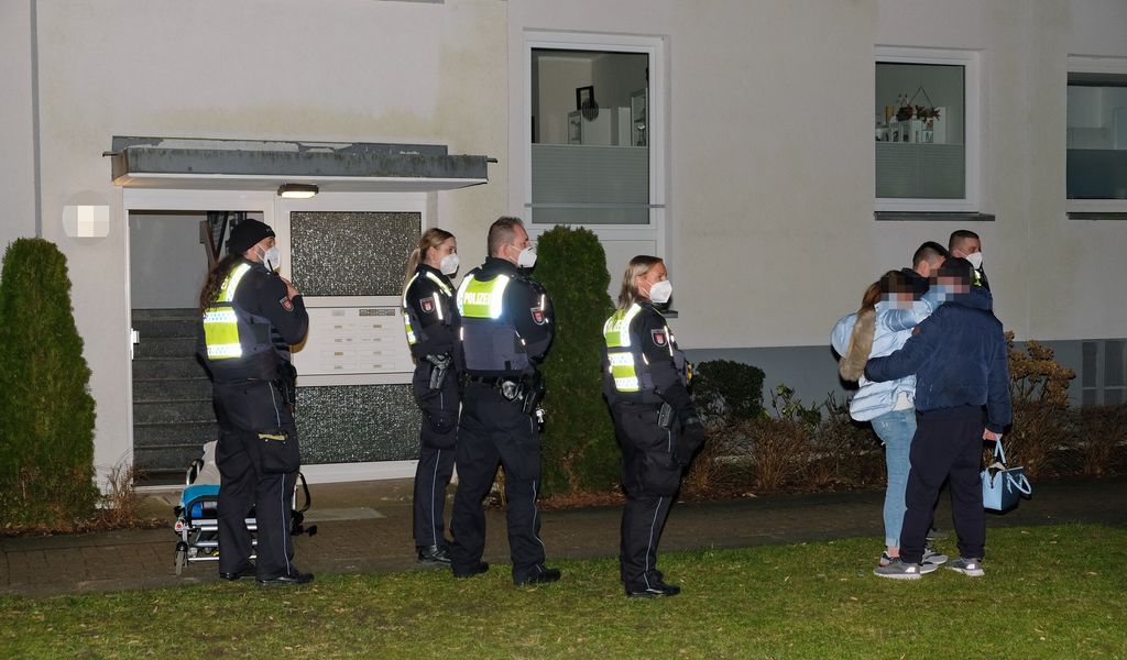 Polizeibeamte stehen in der Tatnacht mit einem der Opfer vor dem Mehrfamilienhaus in Hamburg-Lohbrügge. (Archivbild)