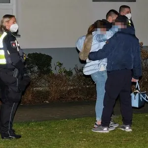 Polizeibeamte stehen in der Tatnacht mit einem der Opfer vor dem Mehrfamilienhaus in Hamburg-Lohbrügge. (Archivbild)