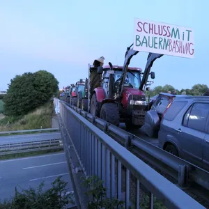„Schluss mit Bauern-Bashing“ steht auf einem Schild an einem Traktor.