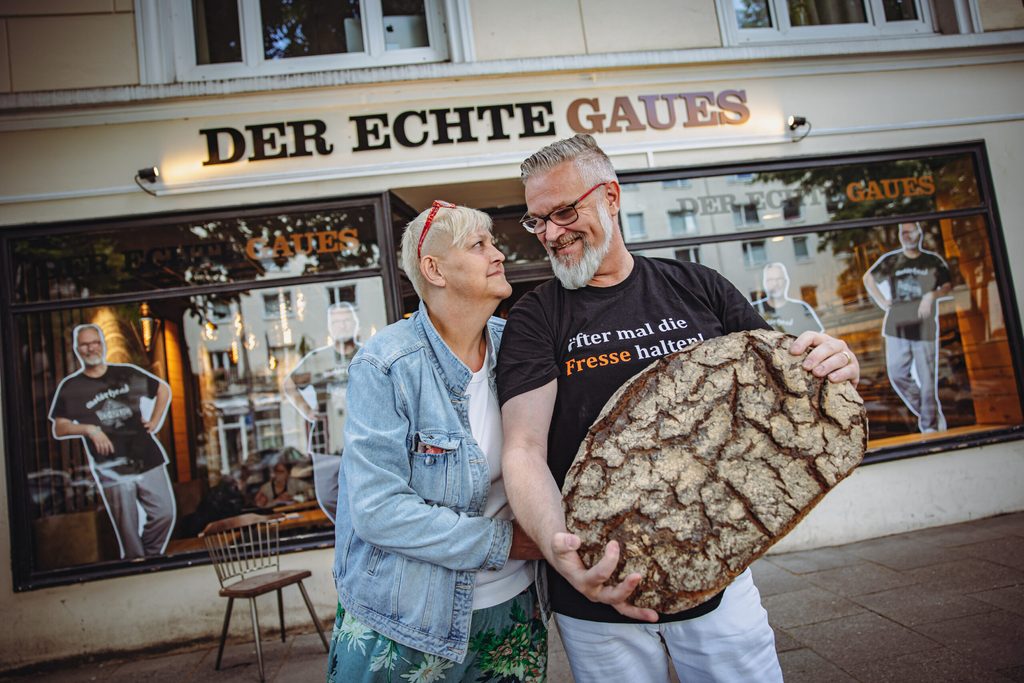 Jochen Gaues (56) mit Ehefrau Betty (55) vor der Bäckerei am Lehmweg: Sie wagen mal wieder einen Neuanfang.