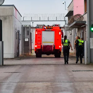 Polizei- und Feuerwehrkräfte betreten das Gefängnisgelände.