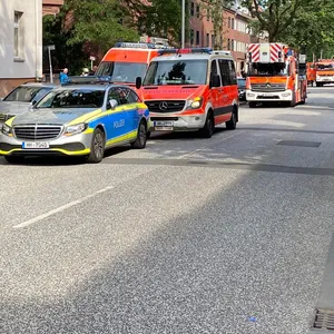 Polizei- und Feuerwehr-Fahrzeuge parken vor dem Wohnhaus in Heimfeld.