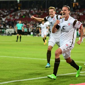 Jackson Irvine wird nach seinem späten 2:2 von den jubelnden Mitspielern verfolgt.