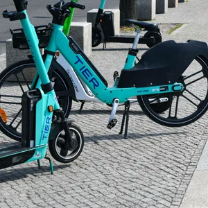 Ein eScooter und E-Bike der Firma Tier stehen in Berlin an einer Straße zum mieten.