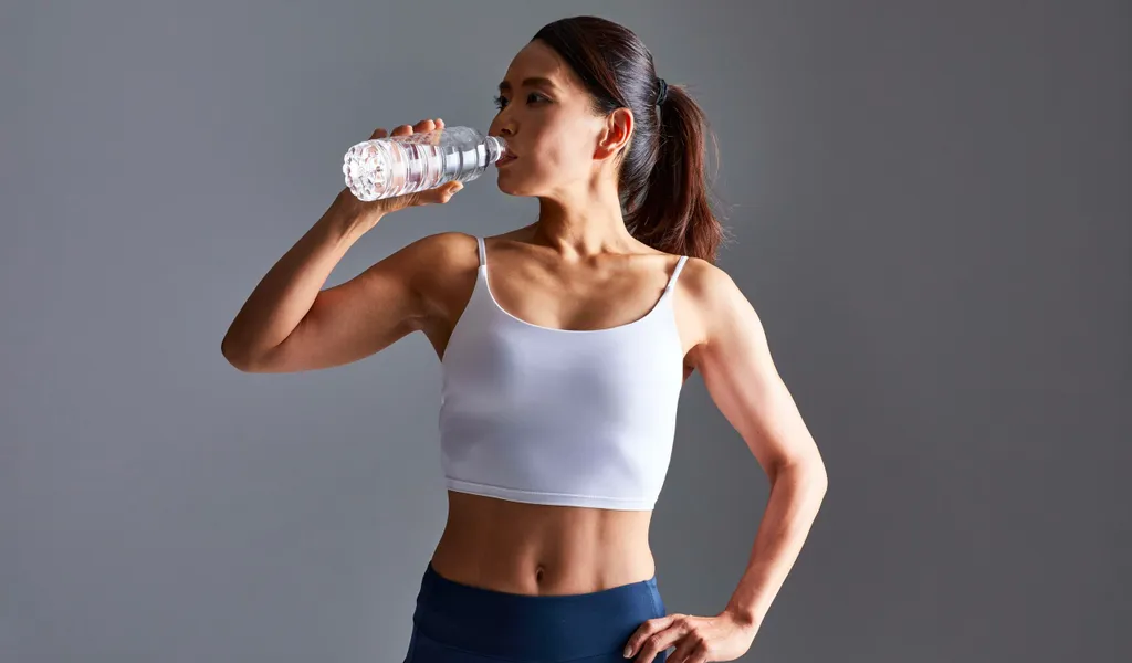 Frau trinkt Wasser beim Sport