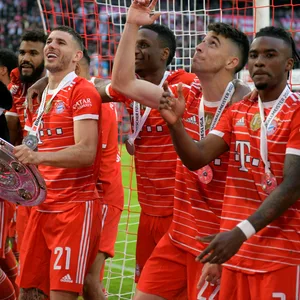 Bayern Münchens Omar Richards (r.) feiert die Meisterschaft mit seinen Teamkollegen.