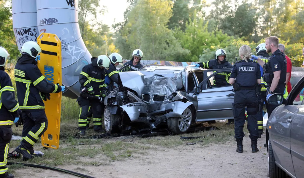 Polizei- und Feuerwehrkräfte am total zerstörten BMW. Die Insassen kamen verletzt ins Krankenhaus.