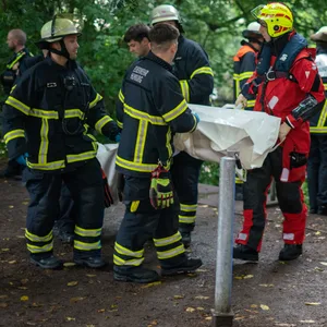 Rettungskräfte tragen eine große weiße Plane