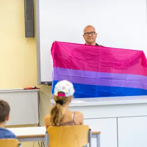 Lehrer mit Flagge und zwei Schülern