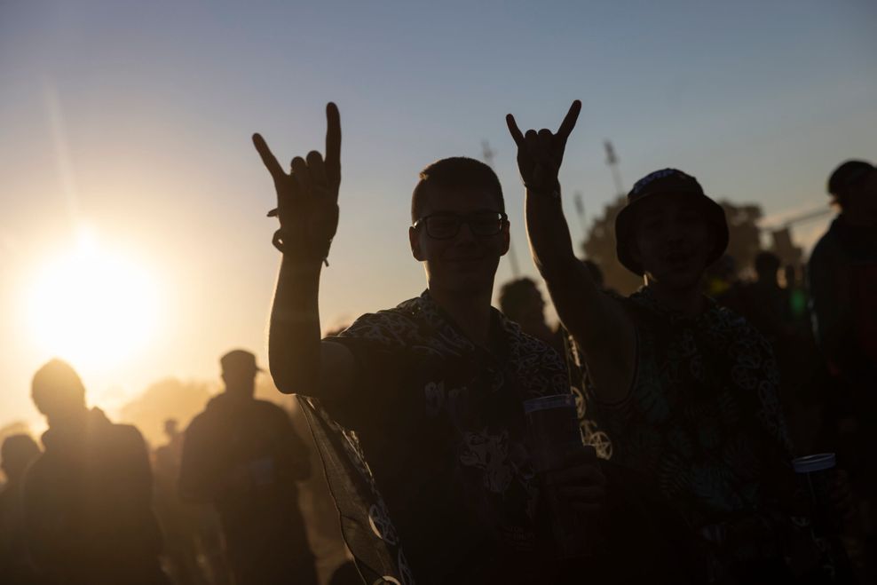 Besucher des Festivals zeigen den "Horn"-Gruß