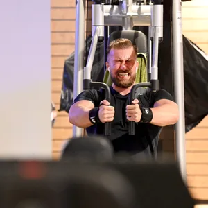 Na, ob das so viel bringt? Ein Mann trainiert mit schmerzverzerrtem Gesicht in einem Fitnessstudio.