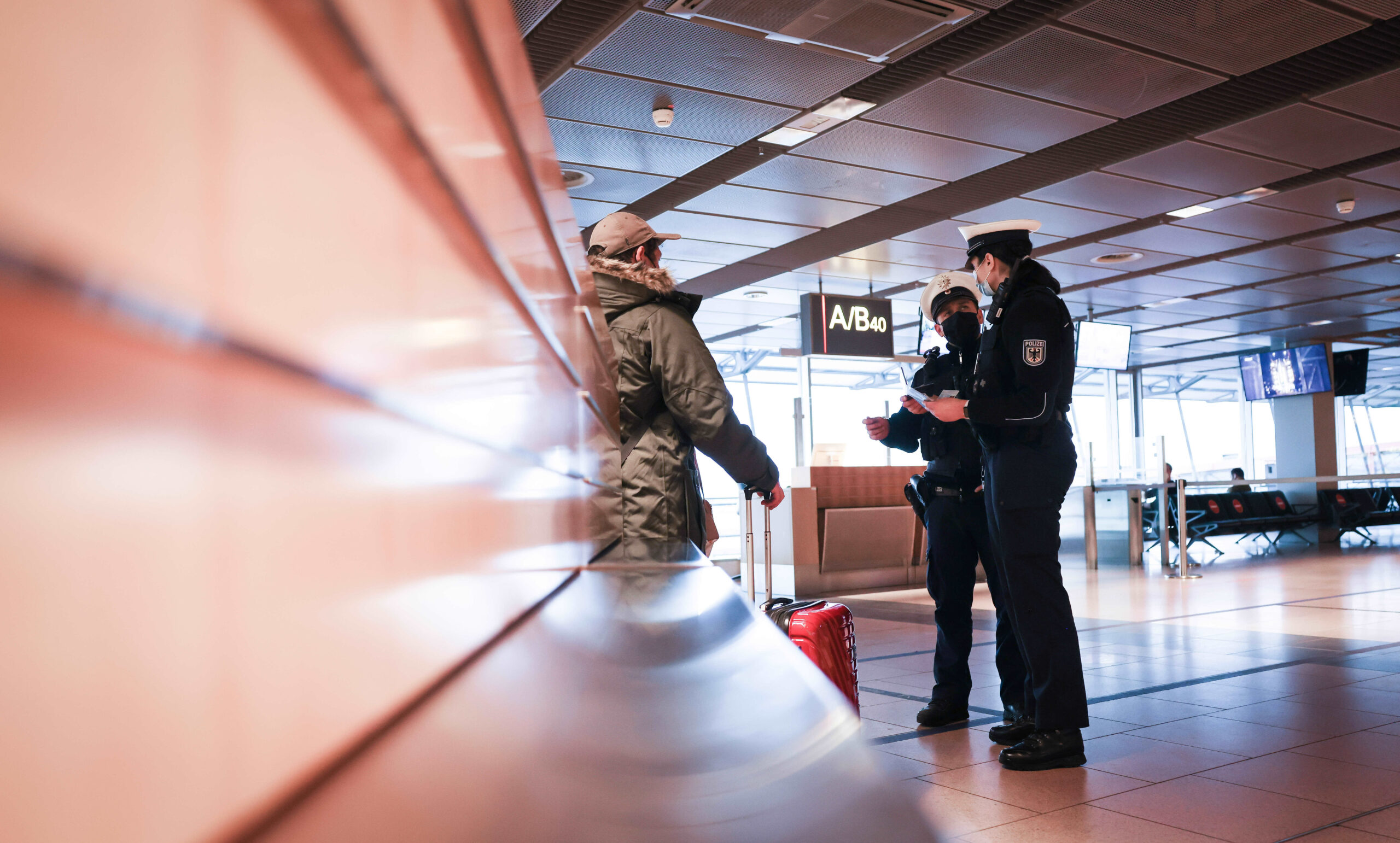 Zwei Beamte der Bundespolizei kontrollieren am Flughafen einen Mann (Symbolbild).