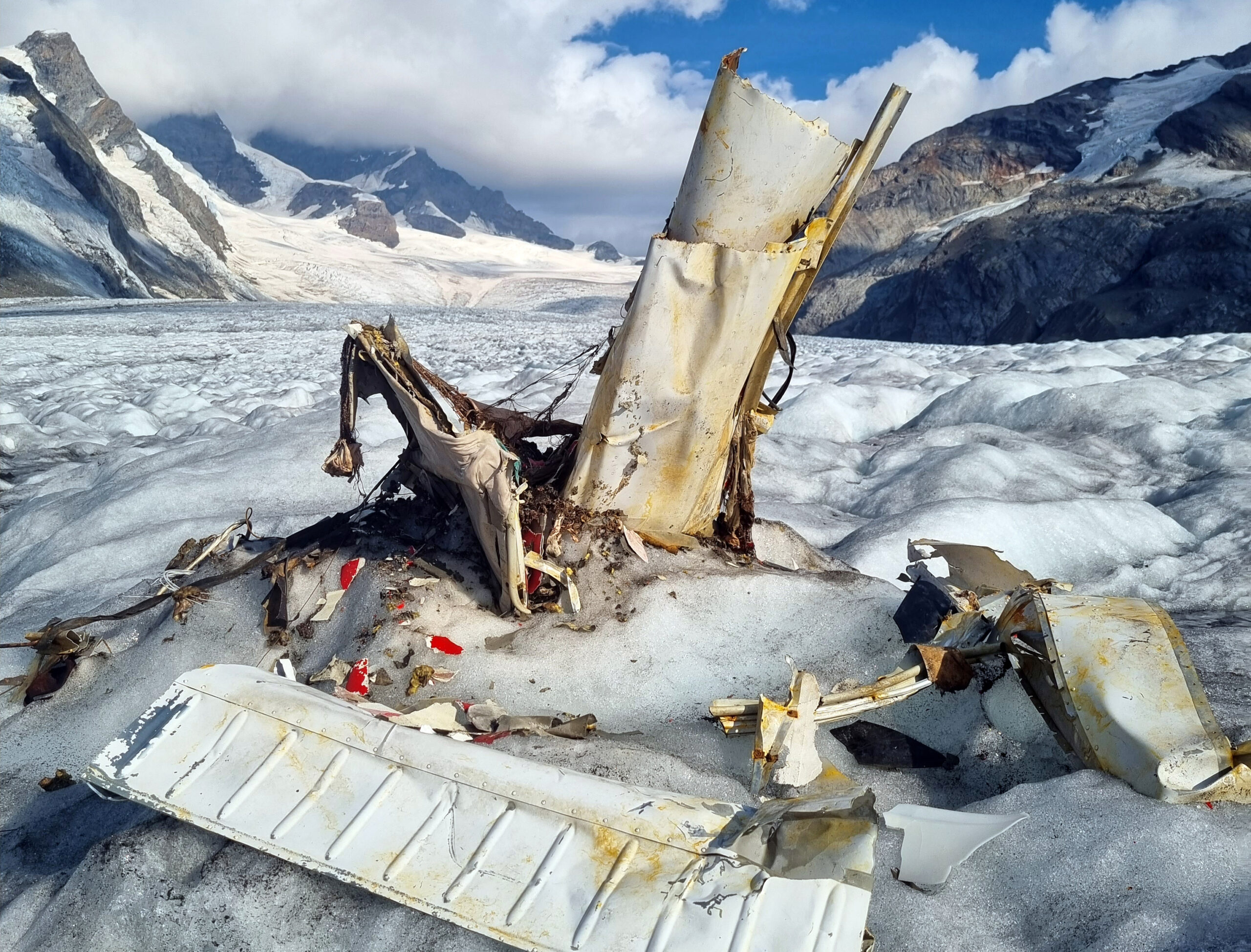 Trümmer eines 1968 abgestürztes Kleinflugzeugs liegen auf dem schmelzenden Aletschgletscher in den Walliser Alpen - im Hintergrund ist das Jungfraujoch zu sehen.