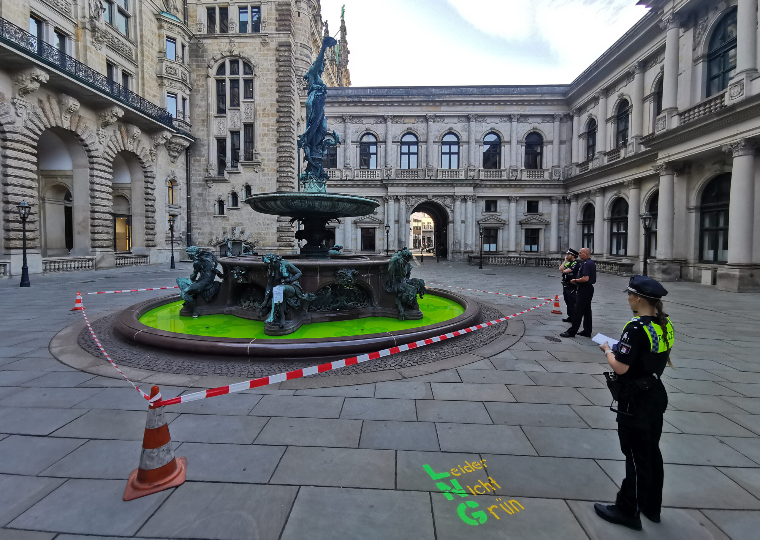 Die Polizei sichert den Brunnen im Innenhof des Rathauses, nachdem Aktivisten von Extinction Rebellion eine grüne Flüssigkeit in das Wasser geschüttet hatten.