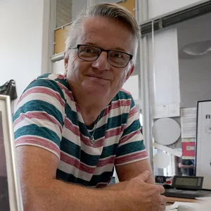 Hausmeister André Schulz sitzt in seinem Büro neben einem Foto von Bela B., Mitglied der Band Die Ärzte.