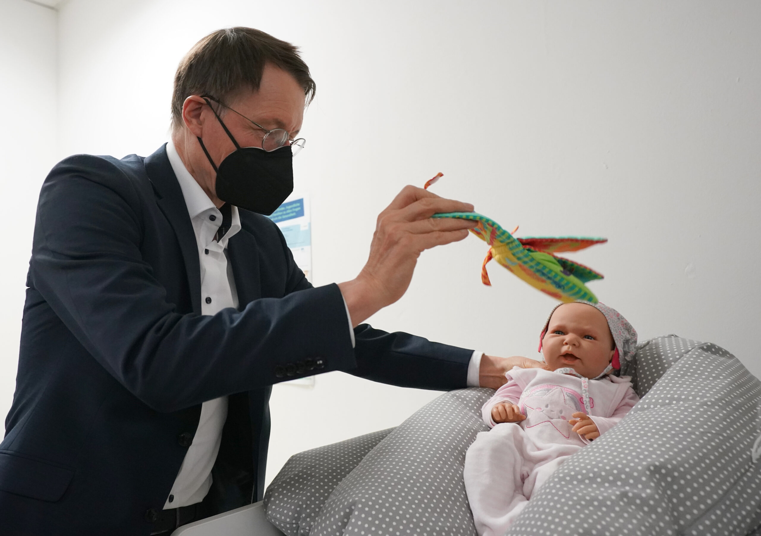 Karl Lauterbach (SPD), Bundesminister für Gesundheit, schaut sich ein Baby-Dummy im Beratungsraum für junge Familien, Kinder und Hebammen im Gesundheitskiosk im Stadtteil Billstedt an.