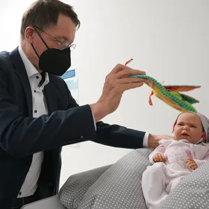 Karl Lauterbach (SPD), Bundesminister für Gesundheit, schaut sich ein Baby-Dummy im Beratungsraum für junge Familien, Kinder und Hebammen im Gesundheitskiosk im Stadtteil Billstedt an.