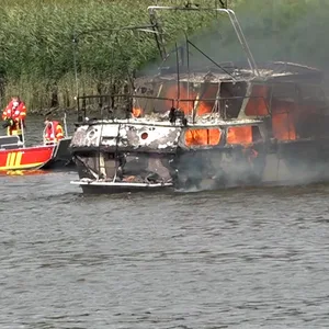 Ein Boot brennt auf dem Wasser, daneben ein Feuerwehrboot