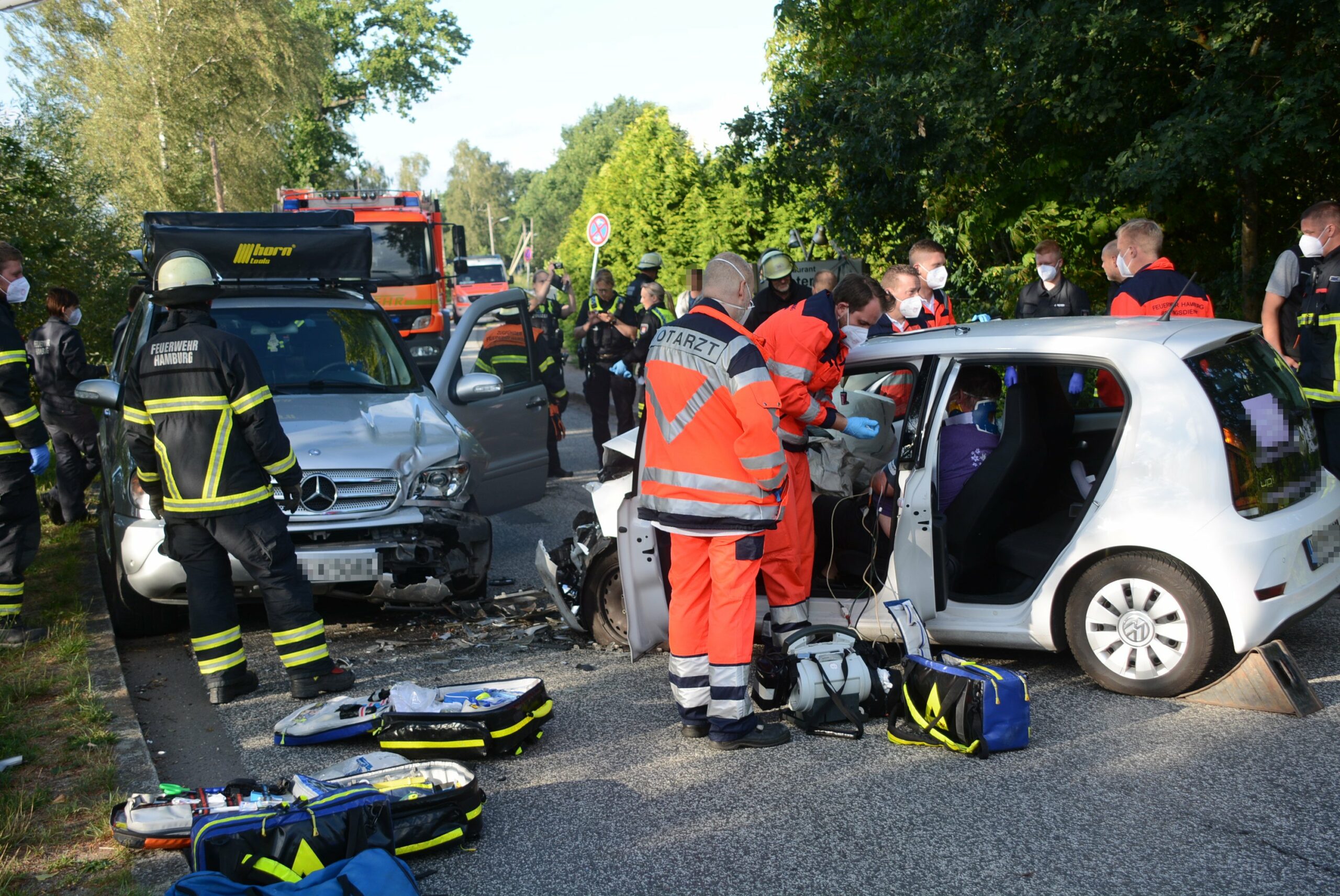 Rettungskräfte stehen neben zwei verunfallten Autos