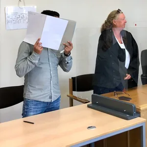 Der Angeklagte verbirgt sein Gesicht vor der Kamera