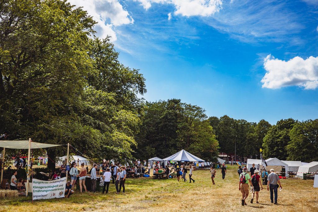 Das „System Change Camp“ befindet sich auf einer Wiese am Altonaer Volkspark. Zu sehen sind das Infozelt im Hintergrund und diverse Workshop- und Gruppen-Zelte.