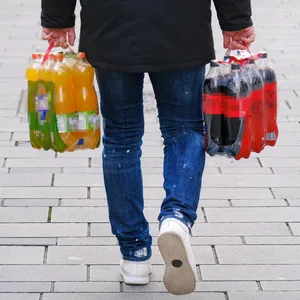 Eine Person trägt Getränkeflaschen vom Einkaufen nach Hause. (Symbolbild)