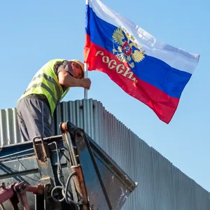 Eine russische Flagge wird an einer Bushaltestelle in Saporischschja gehisst (Symbolbild).