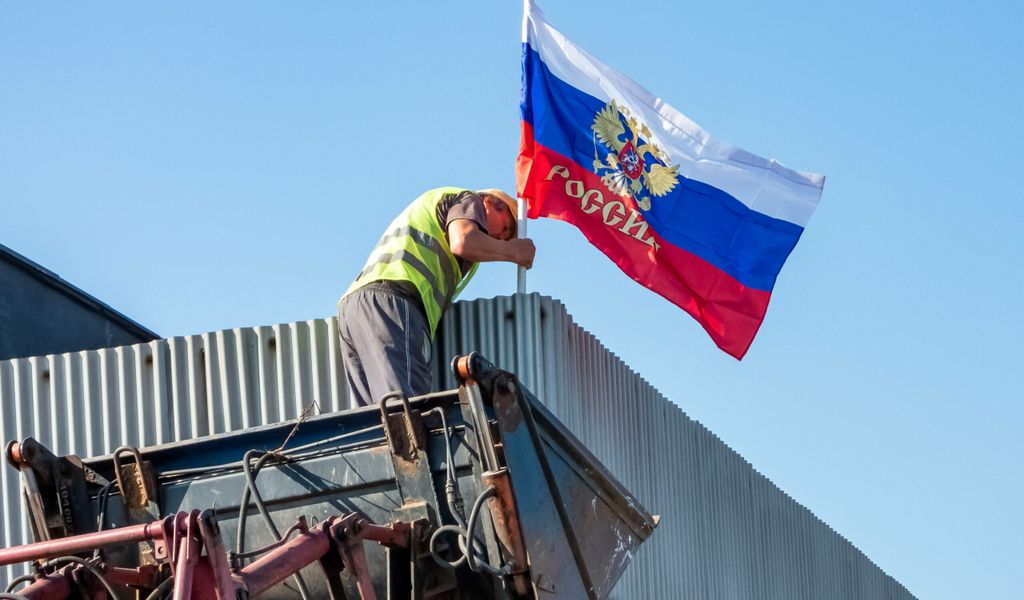 Eine russische Flagge wird an einer Bushaltestelle in Saporischschja gehisst (Symbolbild).