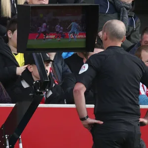 Premier-League-Schiedsrichter Mike Dean schaut sich eine Spielszene über den Videoassistenten erneut an.
