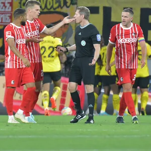Freiburgs Spieler diskutieren mit dem Schiedsrichter