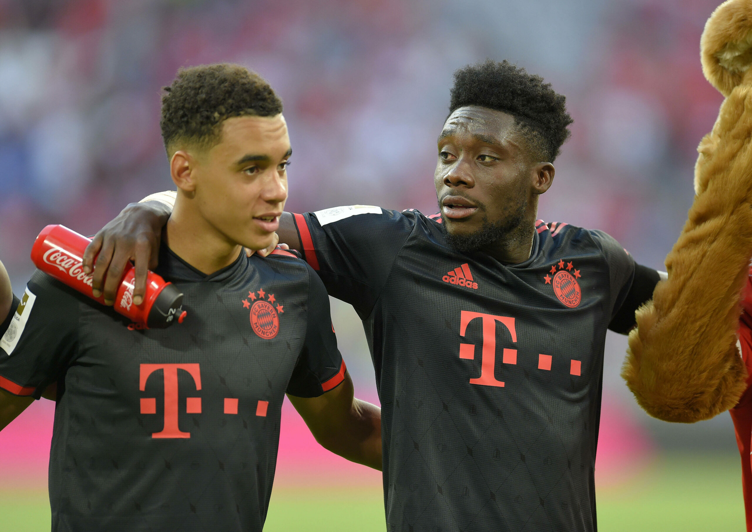 Jamal Musiala (l.) und Alphonso Davies feiern den 2:0-Sieg gegen Wolfsburg.