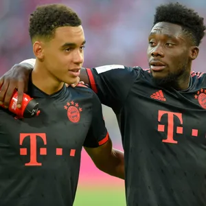 Jamal Musiala (l.) und Alphonso Davies feiern den 2:0-Sieg gegen Wolfsburg.
