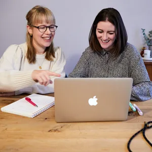 Die Gründerinnen sitzen vor einem Laptop am Schreibtisch.